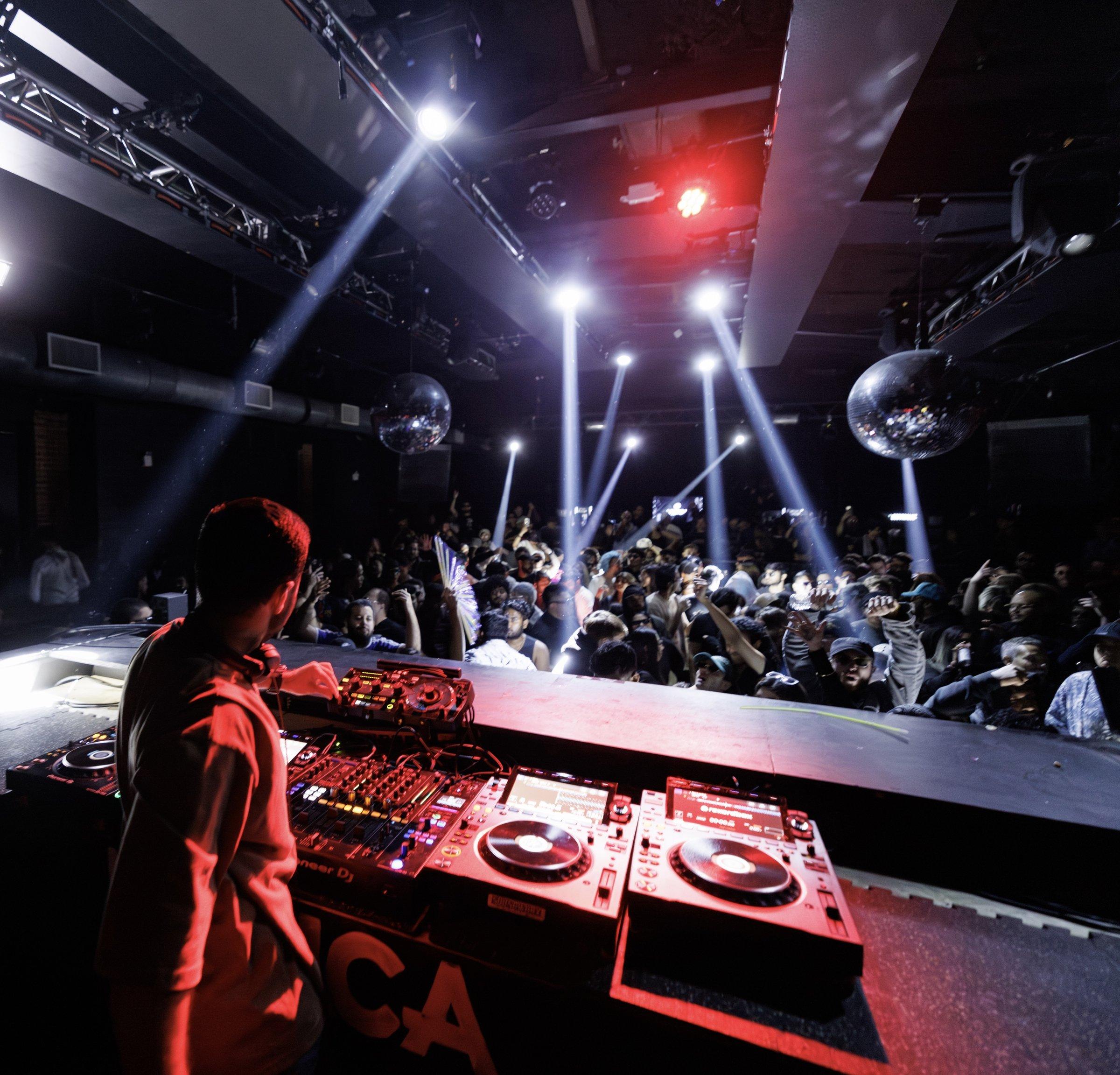 NURAN behind the decks, facing the crowd